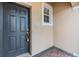 Close-up of the black front door with secure key lock system and a small side window at 3918 Silverlake Way, Wesley Chapel, FL 33544