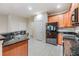 Bright kitchen features granite countertops, wood cabinets, stainless steel appliances, and tile flooring at 3918 Silverlake Way, Wesley Chapel, FL 33544