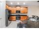 Modern kitchen with granite countertops, stainless steel appliances, wooden cabinets, and tile flooring at 3918 Silverlake Way, Wesley Chapel, FL 33544