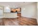 Open-concept kitchen with hardwood floors, dark countertops, wooden cabinets, and stainless steel appliances at 3918 Silverlake Way, Wesley Chapel, FL 33544