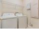 Efficient laundry room featuring a GE washer, dryer and a wire shelf for organized storage at 3918 Silverlake Way, Wesley Chapel, FL 33544