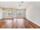 Bright and airy living room featuring hardwood floors, large windows, and a ceiling fan at 3918 Silverlake Way, Wesley Chapel, FL 33544