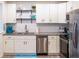 Modern kitchen features white cabinets, stainless steel appliances, granite countertops, and stylish backsplash at 411 Locklie St, Dunedin, FL 34698
