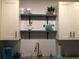 Modern kitchen with white cabinets, open shelving, and granite counters at 411 Locklie St, Dunedin, FL 34698
