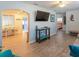 Inviting living room with hardwood floors, entertainment center, and views into the adjacent dining area and bedroom at 411 Locklie St, Dunedin, FL 34698