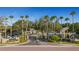 Inviting entrance to Trafalgar Square featuring lush landscaping, palm trees, and gated access for privacy at 4322 Fincastle Ct, Tampa, FL 33624