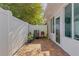 Private fenced-in patio featuring brick pavers, potted plants, and a side entrance door at 4322 Fincastle Ct, Tampa, FL 33624