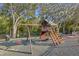 Community playground with swings, slide, and a playhouse surrounded by mature trees at 4322 Fincastle Ct, Tampa, FL 33624