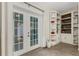 Bright, sunny sunroom with tiled floor, a custom bookshelf, and French doors leading to the patio at 4322 Fincastle Ct, Tampa, FL 33624