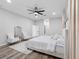 Bright primary bedroom featuring neutral colors, plank flooring, decorative window coverings and modern ceiling fan at 4401 S Trask St, Tampa, FL 33611