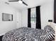 Bedroom with bed, black curtains, ceiling fan and wood floor at 4401 S Trask St, Tampa, FL 33611