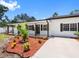 Beautifully landscaped front yard with mulch, accent plants, and a freshly paved driveway at 4401 S Trask St, Tampa, FL 33611