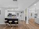 Open-concept living space featuring kitchen with breakfast bar, decorative columns, and wood-look flooring at 4401 S Trask St, Tampa, FL 33611