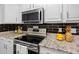Close-up of a modern kitchen with stainless steel appliances, granite countertops, and sleek black backsplash at 4401 S Trask St, Tampa, FL 33611