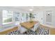 Dining room with large windows, hardwood floors, and a wooden table with white chairs at 4711 12Th N St, St Petersburg, FL 33703