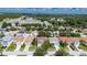An aerial view of a residential neighborhood reveals well-maintained homes with lush greenery and a road in the background at 4735 Red Pine Way, Wesley Chapel, FL 33545