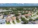 An aerial view shows a landscaped neighborhood with many homes, green trees, and a beautiful community in the background at 4735 Red Pine Way, Wesley Chapel, FL 33545