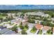 An aerial view shows a suburban neighborhood with well-maintained lawns, mature trees, and a view of the highway at 4735 Red Pine Way, Wesley Chapel, FL 33545