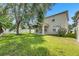 Large backyard area with a green lawn, mature trees, and partial home view at 4735 Red Pine Way, Wesley Chapel, FL 33545