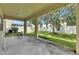 Covered patio and backyard features a well maintained lawn and fence at 4735 Red Pine Way, Wesley Chapel, FL 33545
