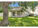Spacious backyard with grass, large tree, and patio with furniture at 4735 Red Pine Way, Wesley Chapel, FL 33545