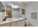Well-lit bathroom with double vanity sinks, large mirror, and a clean, modern aesthetic at 4735 Red Pine Way, Wesley Chapel, FL 33545