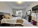 A well-lit bedroom with a dark wood bed frame and a matching dresser at 4735 Red Pine Way, Wesley Chapel, FL 33545