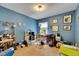 Cozy bedroom with blue walls and a functional workspace area, perfect for relaxation and productivity at 4735 Red Pine Way, Wesley Chapel, FL 33545