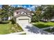 Lovely home featuring a two-car garage, landscaped yard, and classic architectural details at 4735 Red Pine Way, Wesley Chapel, FL 33545