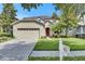 Charming home with lush front lawn, mature tree, mailbox, and attached garage in a serene neighborhood at 4735 Red Pine Way, Wesley Chapel, FL 33545