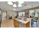 Open kitchen with an island, a sink, and views of the living and dining areas at 4735 Red Pine Way, Wesley Chapel, FL 33545