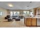 Bright living room and kitchen featuring tile floors, a comfortable sectional sofa, and stainless steel appliances at 4735 Red Pine Way, Wesley Chapel, FL 33545