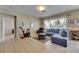 Spacious living room with tile flooring, a comfortable blue sofa, and natural light from the windows at 4735 Red Pine Way, Wesley Chapel, FL 33545