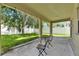 Covered patio with table and chairs overlooking green backyard with fence at 4735 Red Pine Way, Wesley Chapel, FL 33545