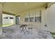 Covered patio with a table and chair set, sliding glass doors to the home at 4735 Red Pine Way, Wesley Chapel, FL 33545