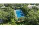 An aerial view of a community tennis court surrounded by lush trees at 4735 Red Pine Way, Wesley Chapel, FL 33545