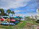 Organized kayak storage with colorful kayaks, palm trees, and picturesque water view at 4985 Cobia Se Dr # A, St Petersburg, FL 33705