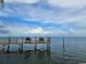 Picturesque pier with chairs overlooking the calm water and a clear blue sky at 4985 Cobia Se Dr # A, St Petersburg, FL 33705