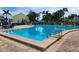 Inviting community pool with lounge chairs, palm trees, and a vibrant yellow building at 4985 Cobia Se Dr # A, St Petersburg, FL 33705