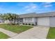 Charming townhome with a well-maintained lawn, mature palm trees, and an attached single car garage at 502 Cara Ct # 502, Largo, FL 33771