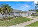 Charming townhome with a well-maintained lawn, mature palm trees, and an attached single car garage at 502 Cara Ct # 502, Largo, FL 33771