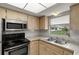 Bright kitchen features stainless steel appliances, laminate countertops, and a double sink with a view at 502 Cara Ct # 502, Largo, FL 33771
