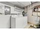Functional laundry area with washer, dryer, storage shelves, and utility connections at 502 Cara Ct # 502, Largo, FL 33771