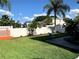 Large grassy backyard features a patio, a fence, and lush green trees and landscaping at 5139 Corvette Dr, Tampa, FL 33624