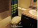 Functional full bathroom featuring a single sink vanity, a standard toilet, and a combined tub and shower with a colorful curtain at 5139 Corvette Dr, Tampa, FL 33624