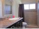 Well-lit main bathroom featuring a single sink vanity, large mirror, and tiled shower area with a neutral color palette at 5139 Corvette Dr, Tampa, FL 33624