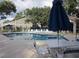 Community swimming pool with lounge chairs, umbrellas, and a building for changing and restroom access at 5139 Corvette Dr, Tampa, FL 33624