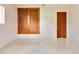 Bedroom featuring terrazzo floors, built-in storage with wood-paneled sliding doors, and a closet at 5221 48Th N Ave, St Petersburg, FL 33709