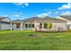Expansive backyard with lush green lawn, mature landscaping, and a covered patio at 6035 Nikki Ln, Odessa, FL 33556