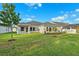 Well-manicured backyard with lush green lawn and healthy landscaping along the home's exterior at 6035 Nikki Ln, Odessa, FL 33556